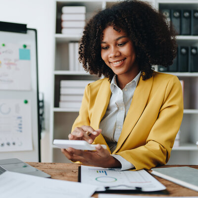 Business account working at computer with paper spreadheets