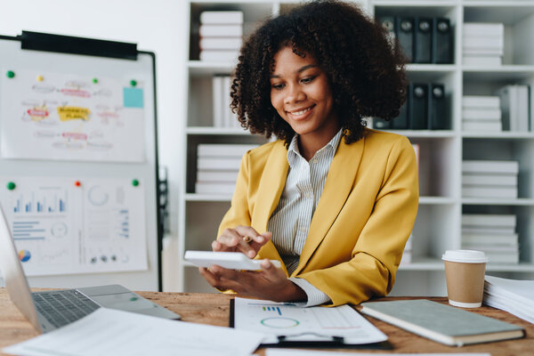 Business account working at computer with paper spreadheets