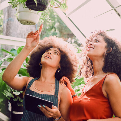 Two females in a greenhouse talking