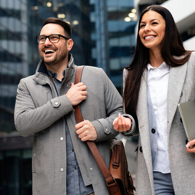 Male and female managers before a glass building