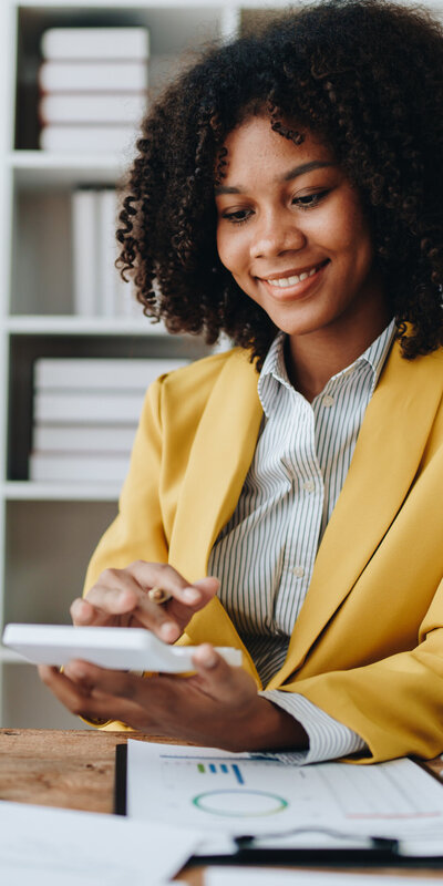 Business account working at computer with paper spreadheets