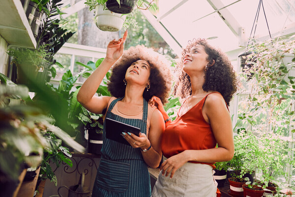 Two females in a greenhouse talking