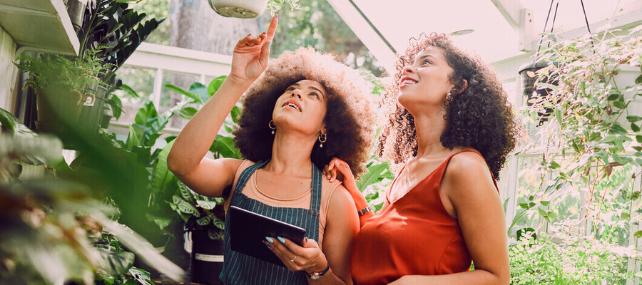 Two females in a greenhouse talking