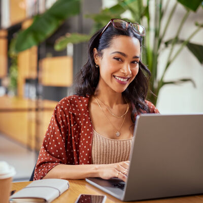 Young woman at computer smiling into camera