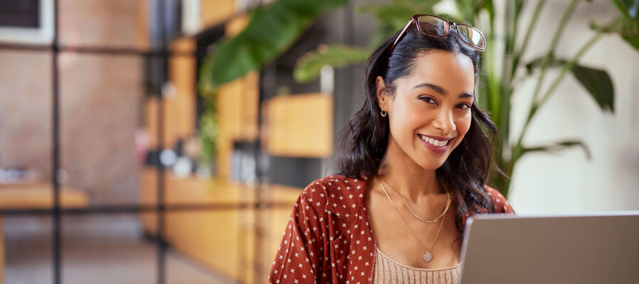 Young woman at computer smiling into camera