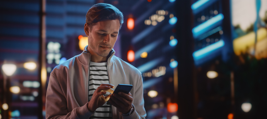 Male controls his account on a mobile phone at night